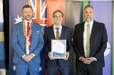 Three people holding awards