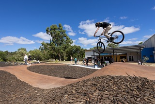 ImageofayoungmandoingaBMXtrickoverajumpportionoftheManningBikeTrackfacility