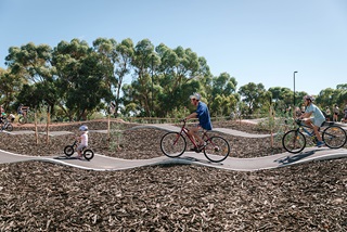 Afamilyofthreeridingbikesalongarollingtrack