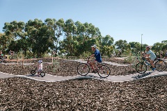Afamilyofthreeridingbikesalongarollingtrack