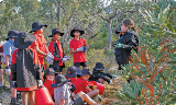 AquinasCollegestudentsstandinginbushlandinSalterPointlisteningtoatalkaboutbushcare