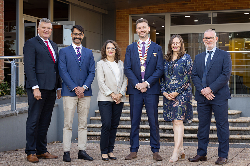 A group of six people smiling.
