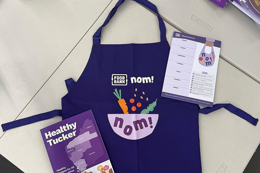 An apron and healthy eating reading materials on a table