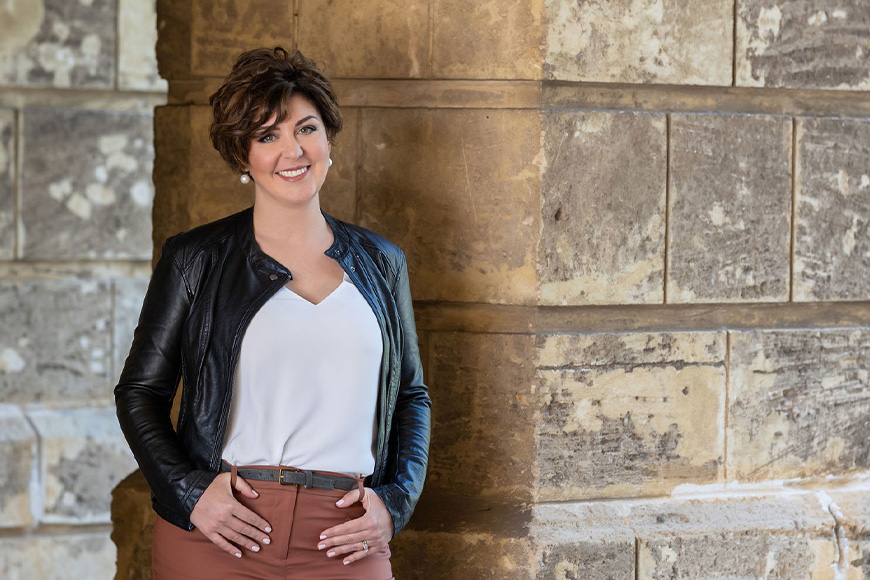 Forensic entomologist Dr Paola Magni standing in front of a limestone wall.