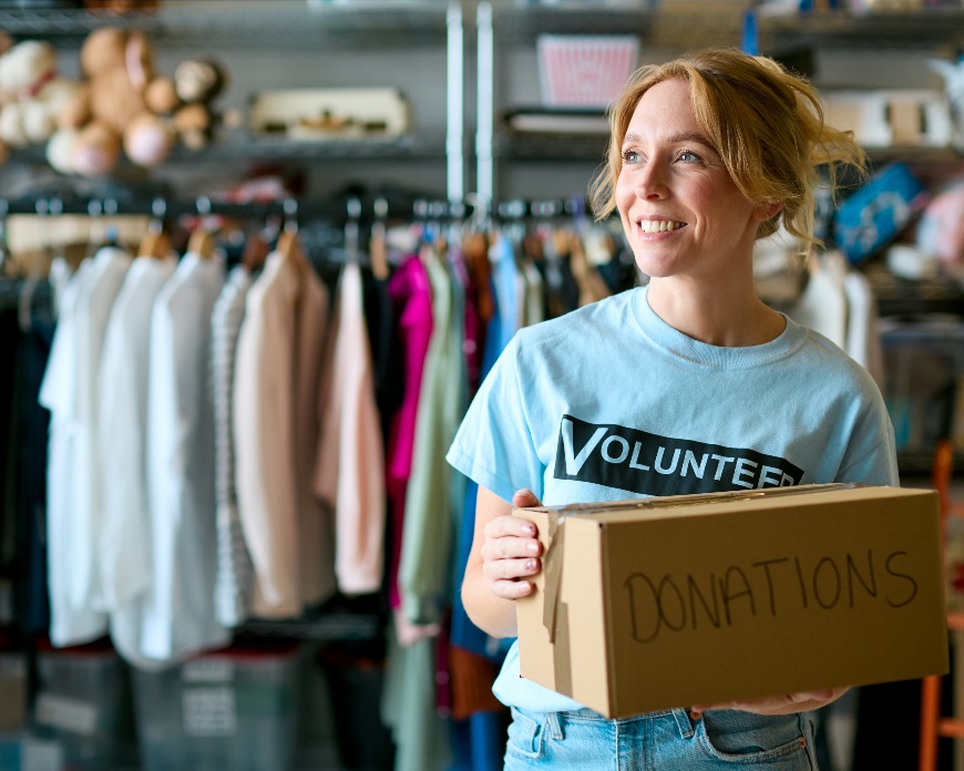 Awomanatanopshopholdingaboxofdonations