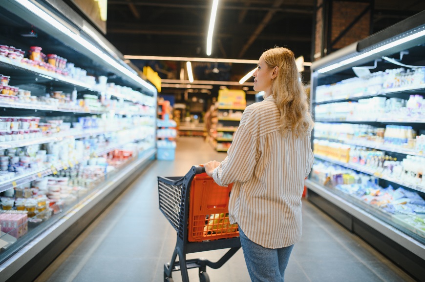 Awomanpushingatrolleythroughasupermarket