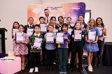 Agroupofchildrenandamanstandinginagroupholdingtheirawards