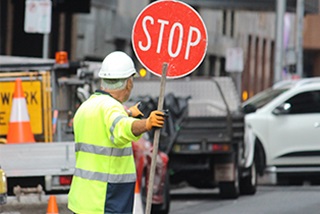 AconstructionworkerholdingaStopsign