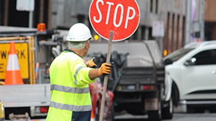 AconstructionworkerholdingaStopsign