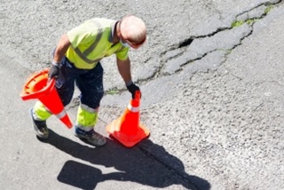 Amaninhighvisplacingtrafficconesontheroad