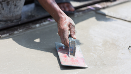 Acloseupofsomeonesmoothingwetconcrete