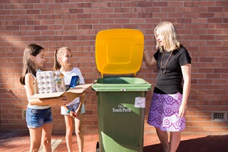 Childrenandadultusingyellowtopbintorecyclecardboard
