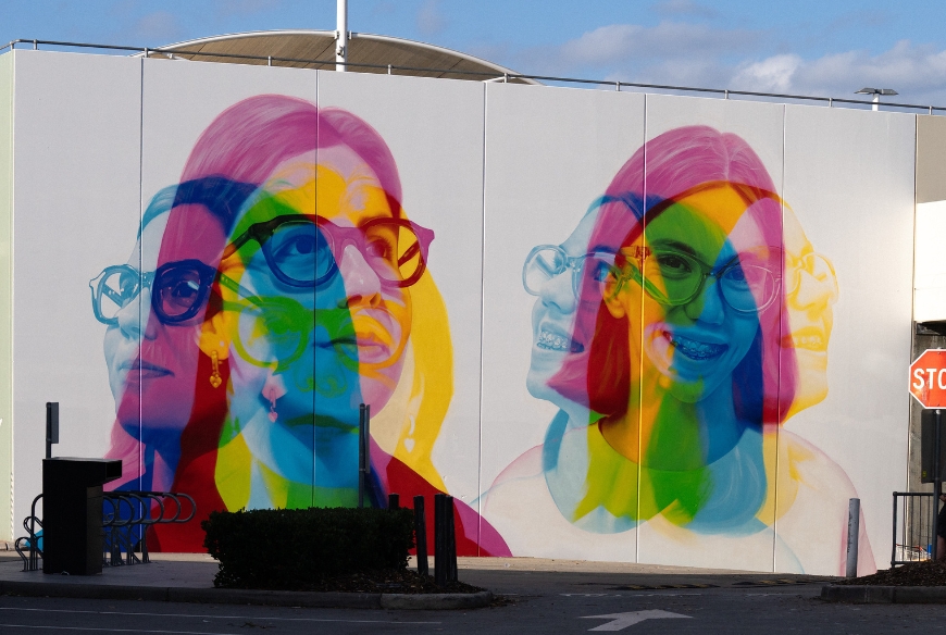 A wall mural comprising to close up portraits of girls with glasses in abstract colours.