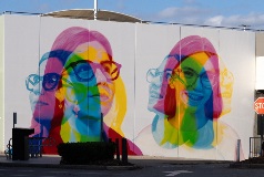 A wall mural comprising to close up portraits of girls with glasses in abstract colours.