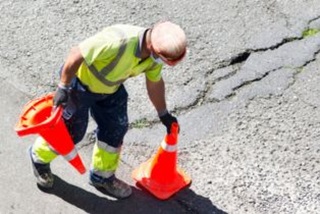 Aroadworkerplacingtrafficconesontheroad