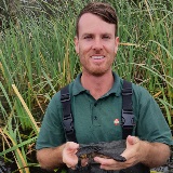 Anthony from Murdoch University holding a snake necked turtle at wetlands